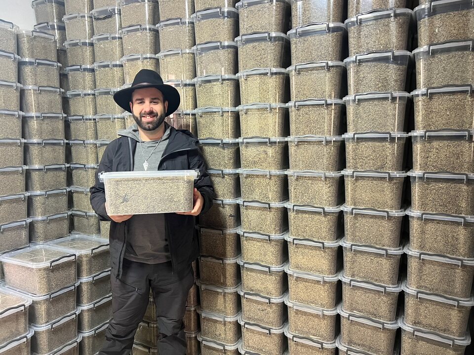 Eric Matzner holding a container of hyperaccumulator seeds